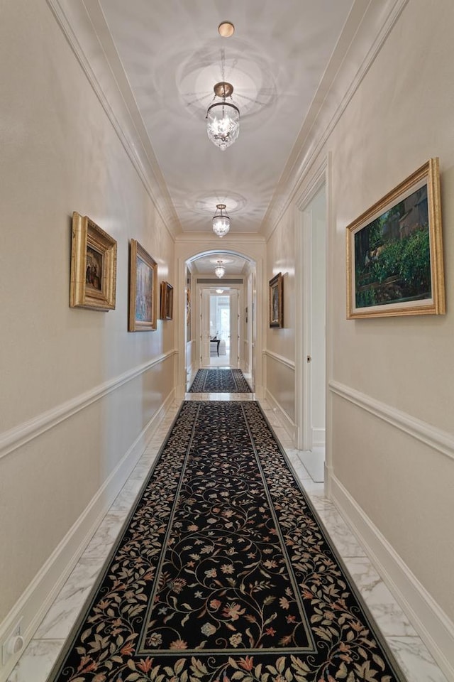 65 E Goethe St Unit 4N, Chicago, IL 60610 - hallway featuring light marble finish floors, arched walkways, ornamental molding, baseboards, and a chandelier