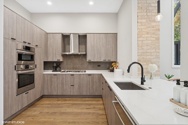 921 N Hoyne Ave Unit 1, Chicago, IL 60622 - kitchen with wall chimney range hood, a sink, appliances with stainless steel finishes, light stone countertops, and modern cabinets