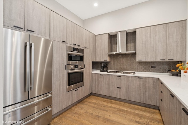 921 N Hoyne Ave Unit 1, Chicago, IL 60622 - kitchen featuring stainless steel appliances, wall chimney range hood, light wood-type flooring, backsplash, and light brown cabinetry