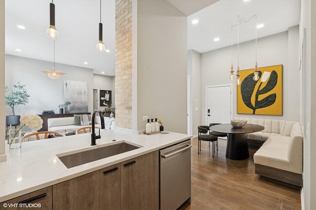 921 N Hoyne Ave Unit 1, Chicago, IL 60622 - kitchen featuring dishwasher, a sink, open floor plan, dark wood-type flooring, and light stone counters
