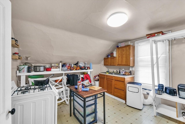 401 S Maple St, Urbana, IL 61801 - kitchen with brown cabinets, light flooring, lofted ceiling, light countertops, and washer / clothes dryer