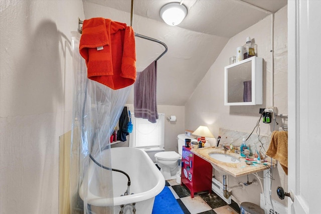 401 S Maple St, Urbana, IL 61801 - bathroom with vaulted ceiling, a freestanding bath, a sink, and toilet
