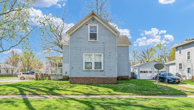 401 S Maple St, Urbana, IL 61801 - view of front of property with a front lawn, an outdoor structure, a detached garage, a shingled roof, and driveway