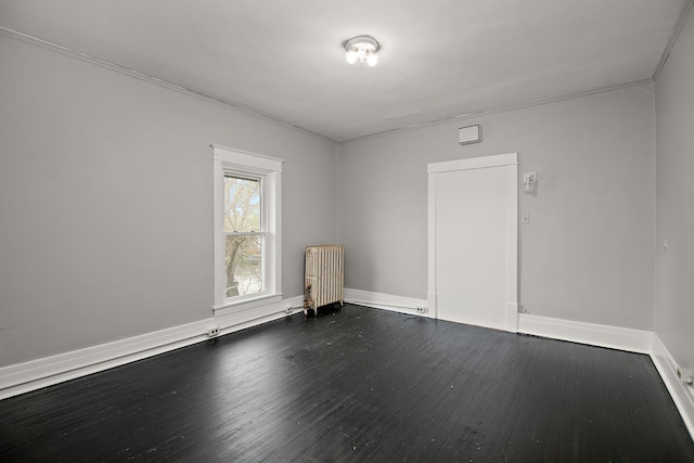 152 S Greenwood Ave, Kankakee, IL 60901 - spare room with radiator heating unit, dark wood finished floors, and baseboards