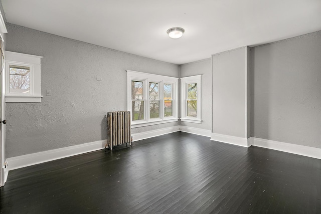 152 S Greenwood Ave, Kankakee, IL 60901 - spare room with radiator heating unit, wood finished floors, a textured wall, and baseboards