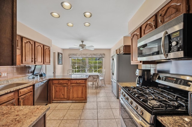 1251 Country Ln, Deerfield, IL 60015 - kitchen with appliances with stainless steel finishes, decorative backsplash, a sink, a ceiling fan, and a peninsula