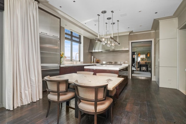 kitchen featuring a kitchen island, dark wood-style floors, light countertops, modern cabinets, and ornamental molding