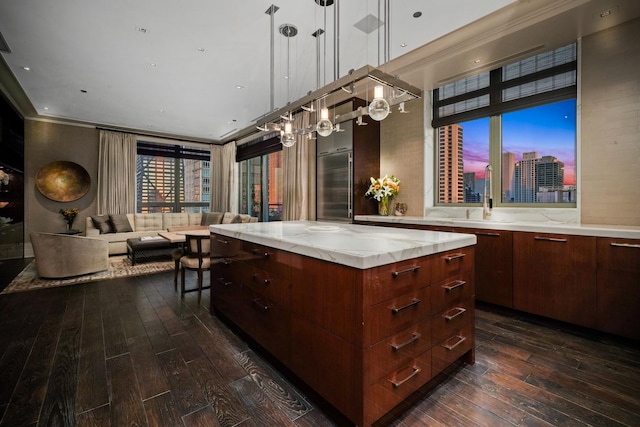 bar area featuring dark wood-style floors, hanging light fixtures, and a sink