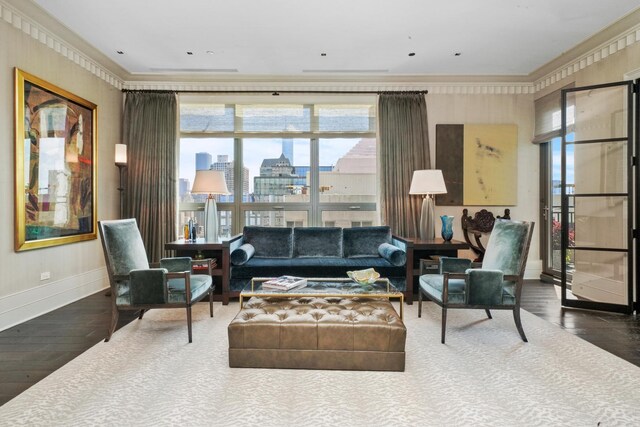 living area featuring wood finished floors, ornamental molding, baseboards, healthy amount of natural light, and a city view