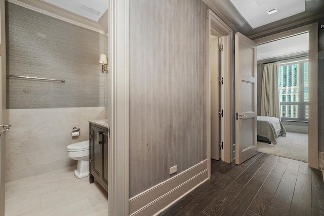 bathroom featuring wood finished floors, vanity, toilet, and crown molding