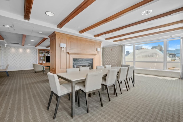 dining area with light colored carpet, beamed ceiling, wallpapered walls, and a city view