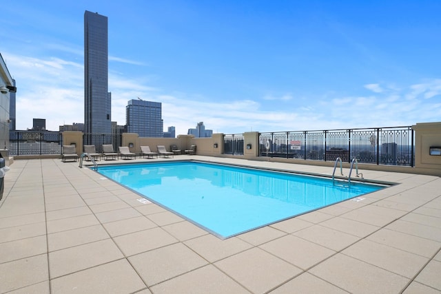 community pool featuring fence and a patio