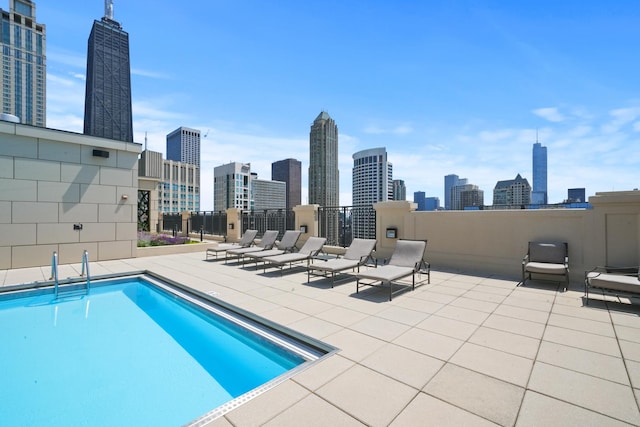community pool featuring a skyline view and a patio area