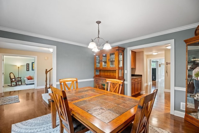 1527 Steeplechase Ct, Green Oaks, IL 60048 - dining space with wood finished floors, a chandelier, crown molding, stairs, and baseboards