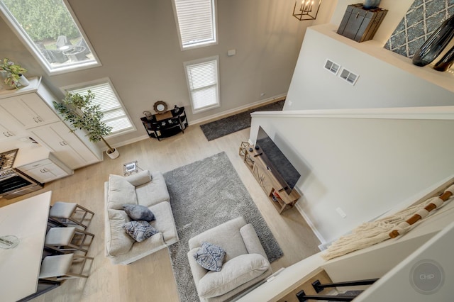 570 Sudbury Cir, Oswego, IL 60543 - living room with wood finished floors, a towering ceiling, and baseboards