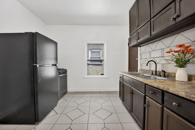 1022 N Lavergne Ave, Chicago, IL 60651 - kitchen featuring freestanding refrigerator, a sink, range with gas stovetop, dark brown cabinets, and baseboards
