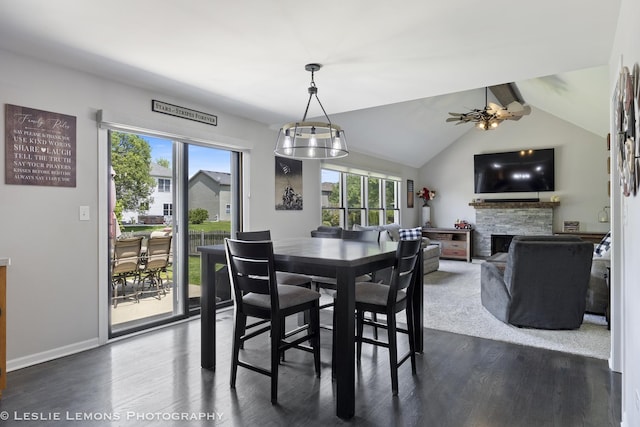 dining room featuring dark wood-style flooring, healthy amount of natural light, a fireplace, and baseboards