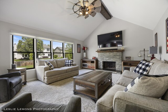 carpeted living area with a fireplace, beamed ceiling, ceiling fan, and high vaulted ceiling