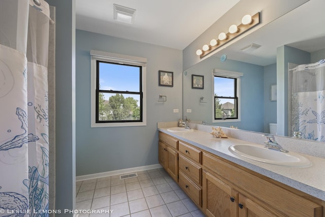 full bath with baseboards, toilet, double vanity, tile patterned flooring, and a shower with curtain
