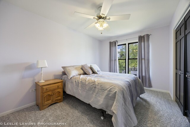 bedroom featuring light colored carpet, baseboards, and a ceiling fan