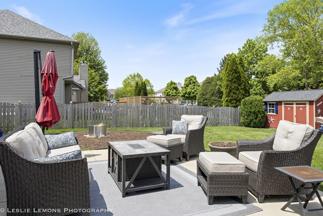 view of patio / terrace featuring an outdoor hangout area, a storage unit, and an outbuilding