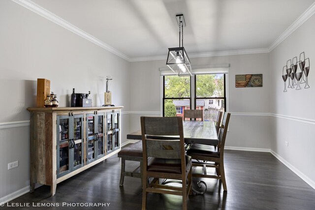dining area featuring dark wood-type flooring, crown molding, and baseboards
