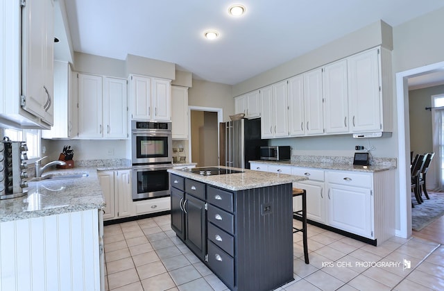 36708 Old Woods Trl, Gurnee, IL 60031 - kitchen featuring stainless steel appliances, white cabinetry, light tile patterned floors, a kitchen island, and dark cabinetry