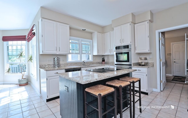 36708 Old Woods Trl, Gurnee, IL 60031 - kitchen with black electric cooktop, light tile patterned floors, white cabinets, and a kitchen island