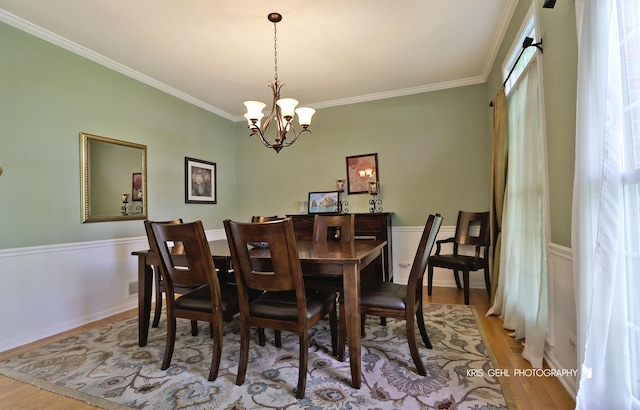 36708 Old Woods Trl, Gurnee, IL 60031 - dining space featuring light wood-style floors, ornamental molding, a chandelier, plenty of natural light, and a wainscoted wall