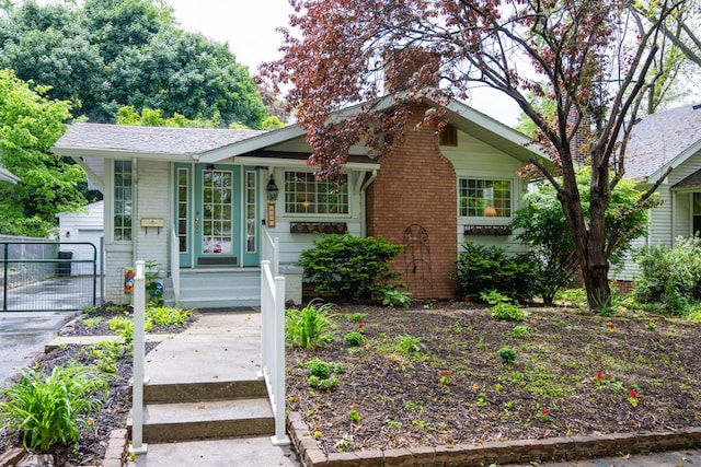 1521 W University Ave, Champaign, IL 61821 - view of front facade with a gate, brick siding, a chimney, and covered porch
