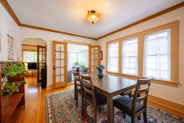 1521 W University Ave, Champaign, IL 61821 - dining area with plenty of natural light, light wood-type flooring, arched walkways, crown molding, and baseboards