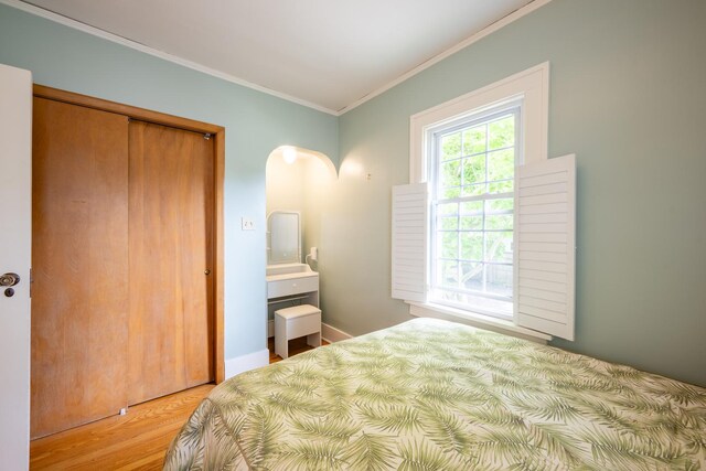 1521 W University Ave, Champaign, IL 61821 - bedroom featuring crown molding, wood finished floors, and a closet