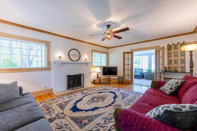1521 W University Ave, Champaign, IL 61821 - living area featuring a ceiling fan, wood finished floors, a fireplace, crown molding, and baseboards
