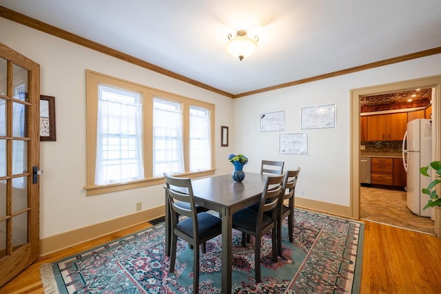 1521 W University Ave, Champaign, IL 61821 - dining space with light wood finished floors, ornamental molding, and baseboards