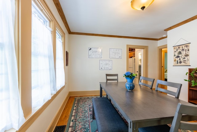 1521 W University Ave, Champaign, IL 61821 - dining area featuring crown molding, wood finished floors, healthy amount of natural light, and baseboards