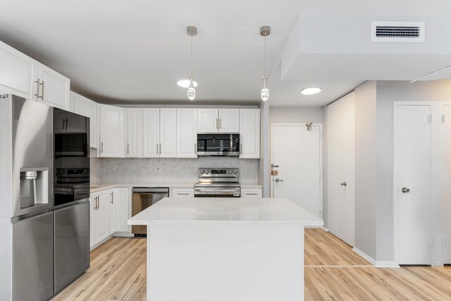 6301 N Sheridan Rd Unit 11D, Chicago, IL 60660 - kitchen with stainless steel appliances, light wood finished floors, and white cabinets