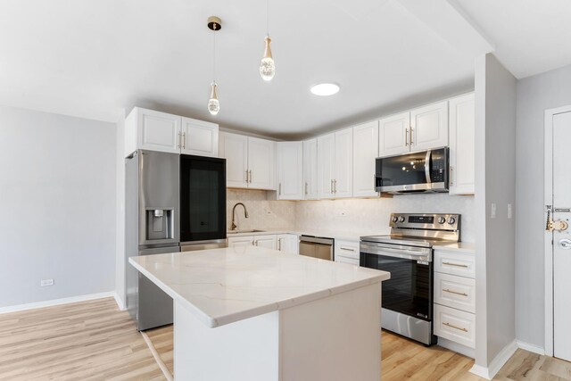 6301 N Sheridan Rd Unit 11D, Chicago, IL 60660 - kitchen with appliances with stainless steel finishes, a sink, baseboards, light wood-style floors, and decorative backsplash