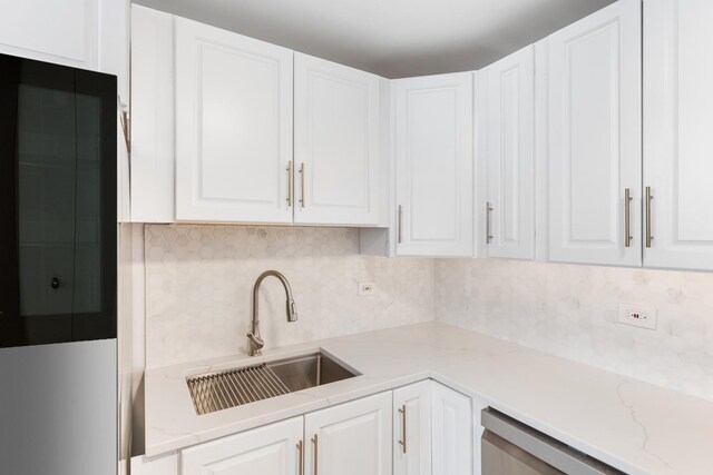 6301 N Sheridan Rd Unit 11D, Chicago, IL 60660 - kitchen featuring a sink, white cabinetry, backsplash, stainless steel dishwasher, and light stone countertops