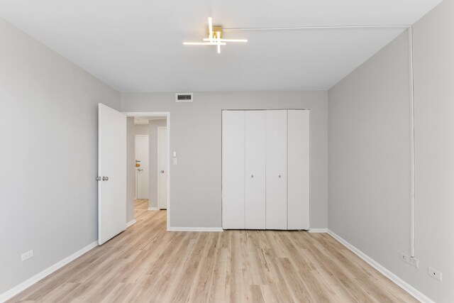 6301 N Sheridan Rd Unit 11D, Chicago, IL 60660 - unfurnished bedroom featuring wood finished floors, baseboards, and a closet