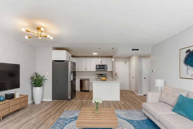 6301 N Sheridan Rd Unit 11D, Chicago, IL 60660 - living room featuring light wood-style floors, a chandelier, and baseboards