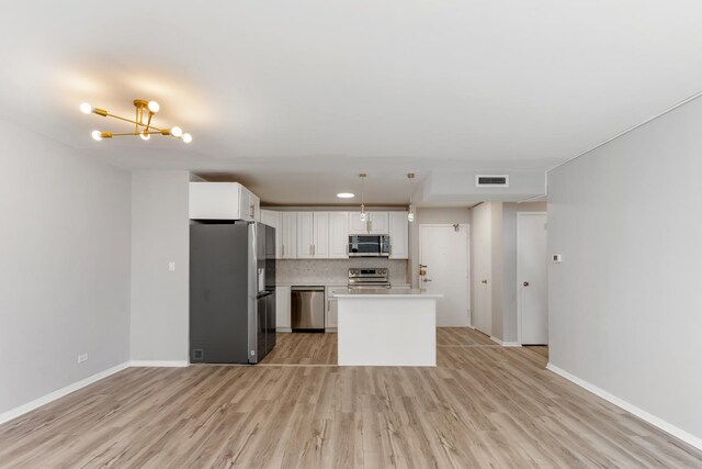 6301 N Sheridan Rd Unit 11D, Chicago, IL 60660 - kitchen with appliances with stainless steel finishes, light wood-style floors, a chandelier, and light countertops