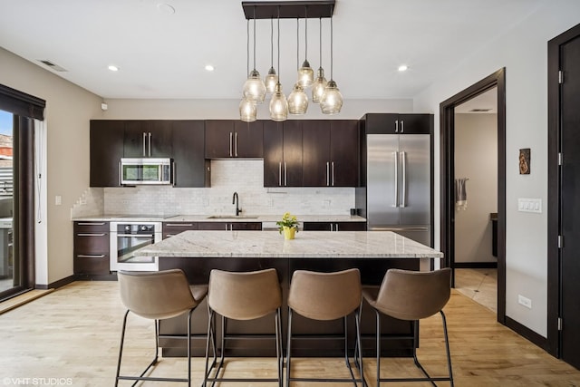 2130 W N Ave Unit 208, Chicago, IL 60647 - kitchen with stainless steel appliances, a sink, a kitchen breakfast bar, a kitchen island, and tasteful backsplash