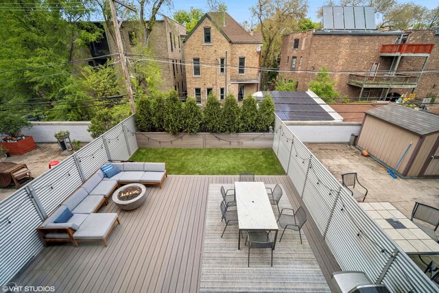 2130 W N Ave Unit 208, Chicago, IL 60647 - wooden terrace with a fire pit, outdoor dining area, and a fenced backyard