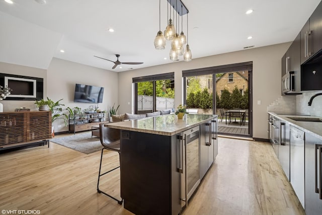 2130 W N Ave Unit 208, Chicago, IL 60647 - kitchen featuring wine cooler, a sink, modern cabinets, a center island, and light wood-style flooring