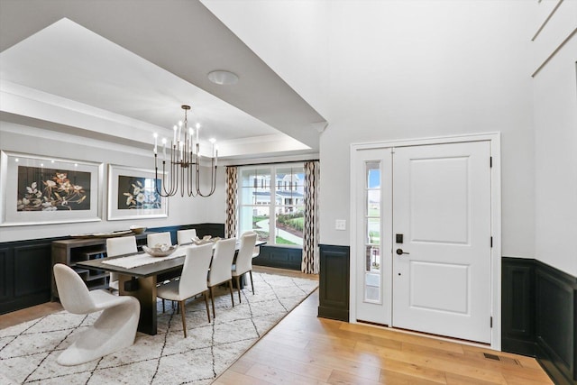 617 Henry Ln, Oswego, IL 60543 - dining area featuring a chandelier, light wood-style floors, wainscoting, a tray ceiling, and crown molding