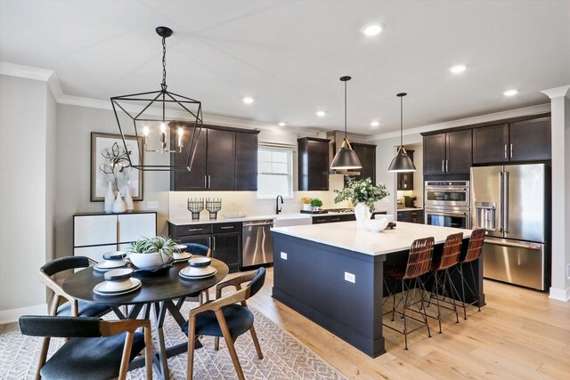 617 Henry Ln, Oswego, IL 60543 - kitchen featuring stainless steel appliances, ornamental molding, a kitchen island, light countertops, and decorative backsplash