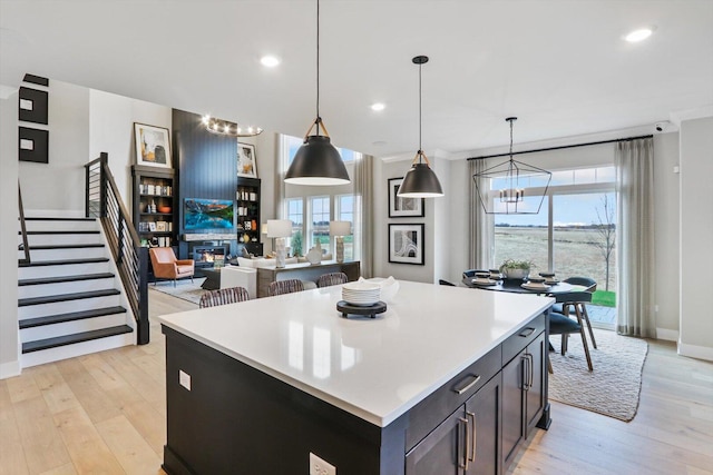 617 Henry Ln, Oswego, IL 60543 - kitchen with a chandelier, light wood finished floors, a kitchen island, light countertops, and hanging light fixtures