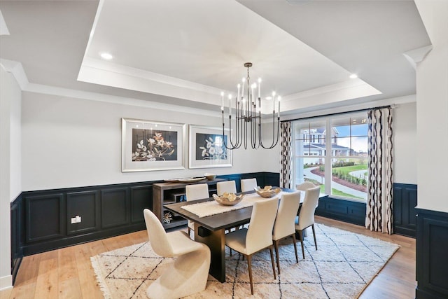617 Henry Ln, Oswego, IL 60543 - dining area with a tray ceiling, a chandelier, light wood finished floors, crown molding, and a decorative wall