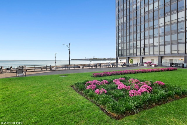 surrounding community featuring a water view and a lawn