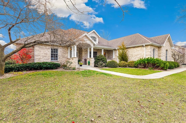 view of front of property featuring brick siding, a front lawn, and a porch